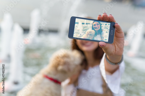 Say cheese. Woman taking selfie with her dog outdoor