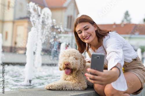 Dogs give us a sense of purpose. Woman taking selfie with her dog outdoor