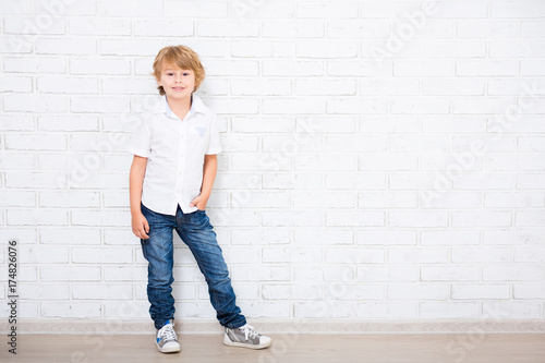 full length portrait of cute little boy posing over white photo