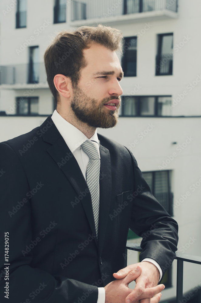 Relaxed businessman standing on balcony of his apartment Relaxed businessman standing on balcony of his apartment