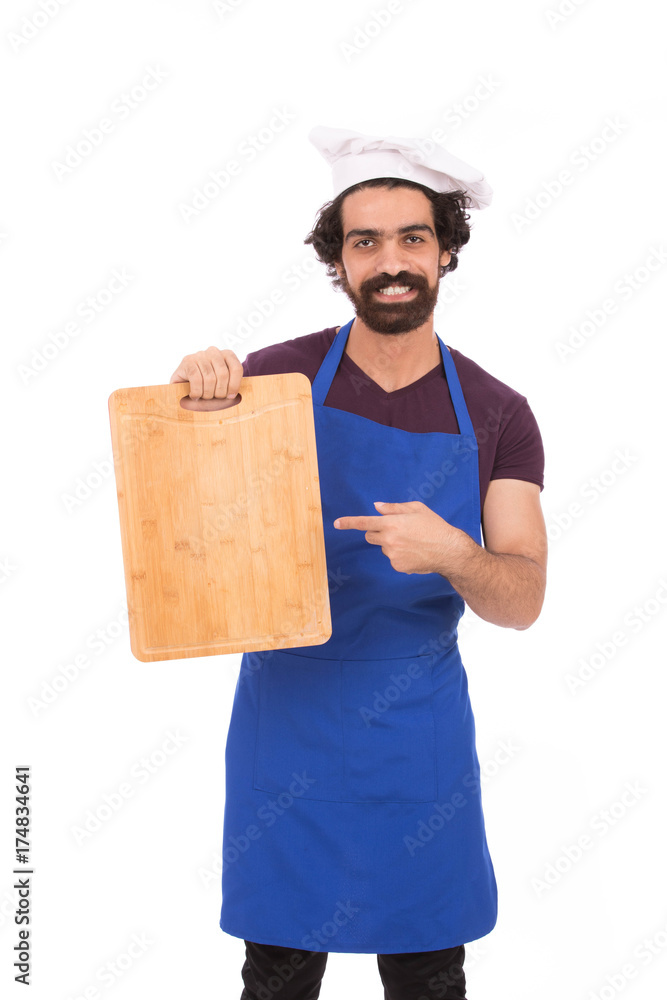 Happy handsome beard chef smiling and holding a wooden cutting board, guy wearing a blue chef uniform and chef hat, isolated on white background Happy handsome beard chef smiling and holding a wooden cutting board, guy wearing a blue chef uniform and chef hat, isolated on white background