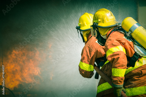 2 firefighters spraying water in cinematic tone