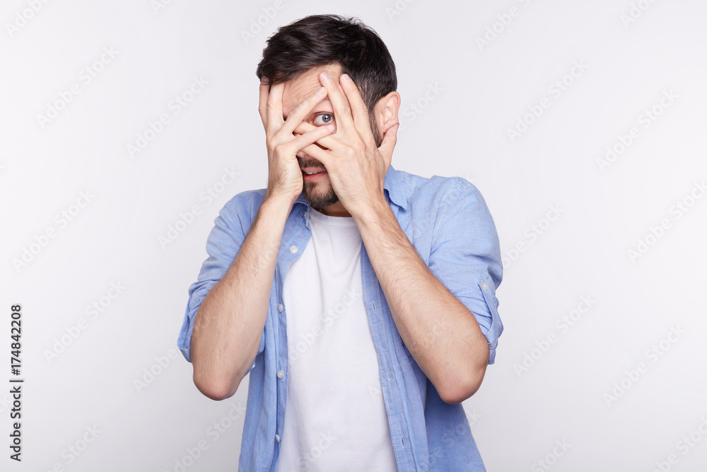 Business, career, stress and failure at work. Close up shot of young blue eyed manager covering face with both hands, feeling stressed, facing deadline, trying to make it to finish project in time. Business, career, stress and failure at work. Close up shot of young blue eyed manager covering face with both hands, feeling stressed, facing deadline, trying to make it to finish project in time.