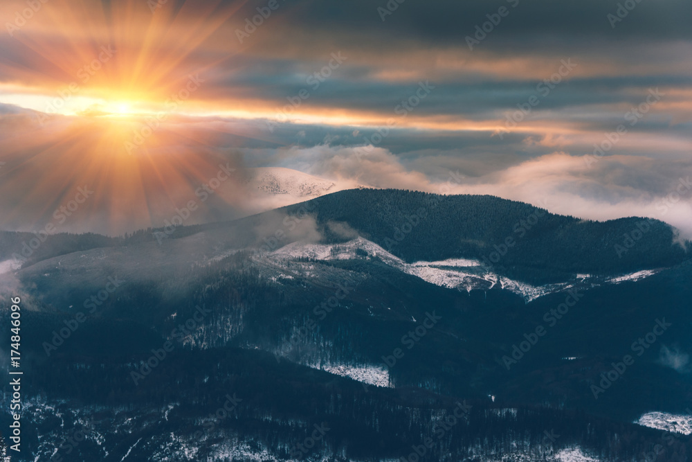 Landscape of colorful sunset in the  winter mountains. Dramatic evening sky.