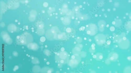 Festive turquoise blue glowing bokeh background with floating light particles.
