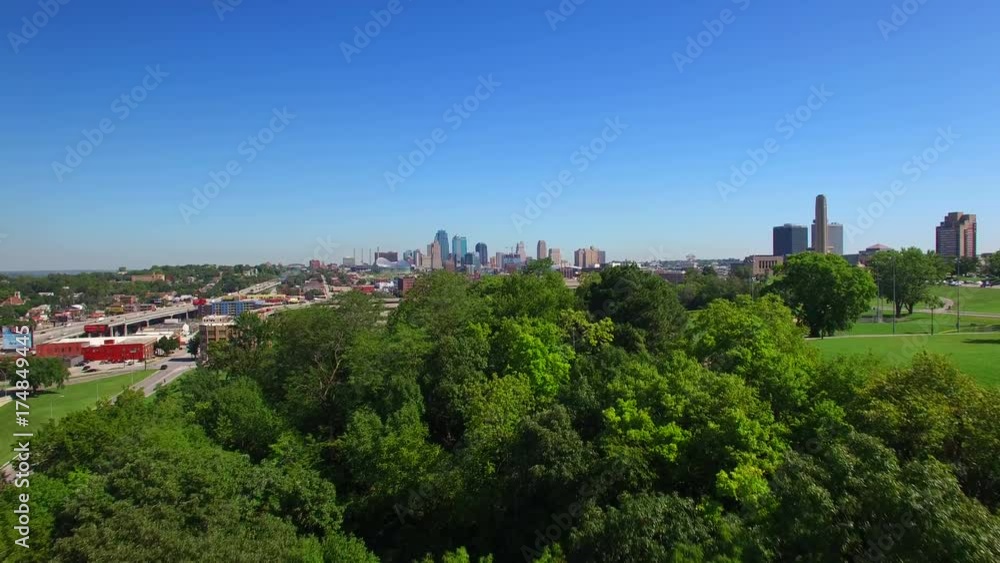 Slow drone flight over trees to reveal the Kansas City skyline. Slow drone flight over trees to reveal the Kansas City skyline.
