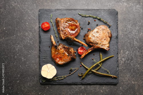 Slate plate with grilled meat on table