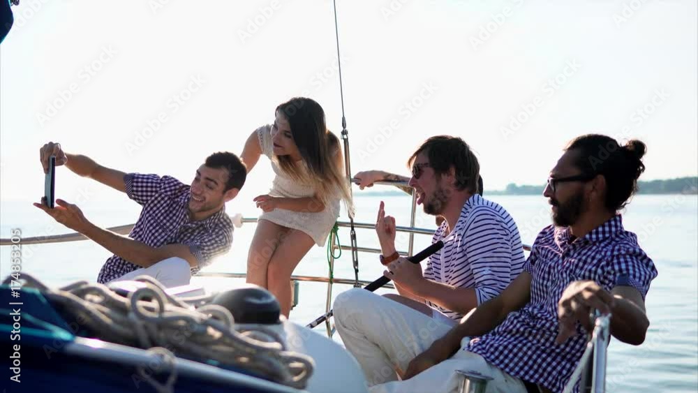 Friends relaxing on the sailing yacht and taking selfie with digital tablet Friends relaxing on the sailing yacht and taking selfie with digital tablet