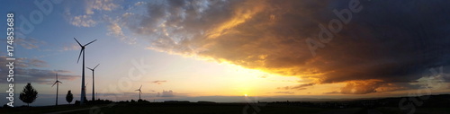 Windkrafträder im Sonnenuntergang als Panorama 