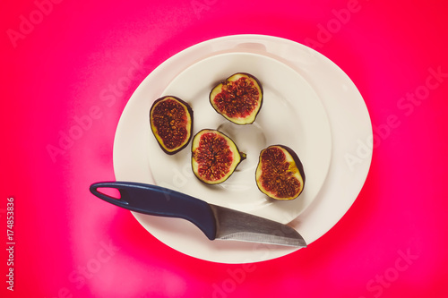 Fresh sweet ripe figs on dark wooden board in a white plate. photo