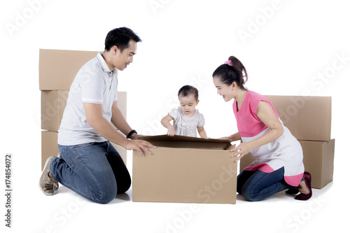 Young family unpacking cardboard on studio