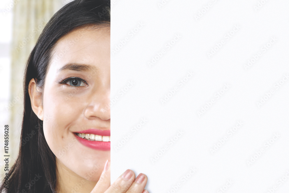 Shy girl peeping behind an empty whiteboard Shy girl peeping behind an empty whiteboard