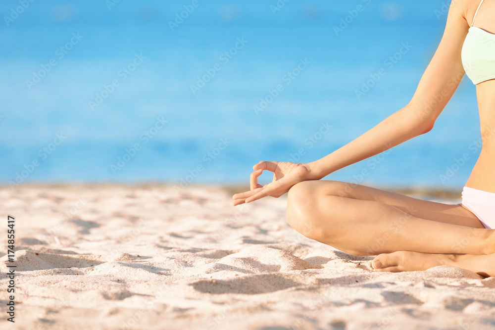 Beautiful young woman practicing yoga on sea beach Beautiful young woman practicing yoga on sea beach