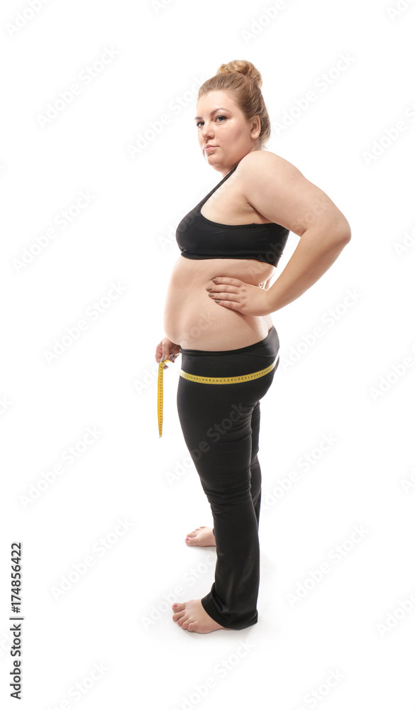 Overweight young woman measuring her hips on white background. Weight loss concept Overweight young woman measuring her hips on white background. Weight loss concept