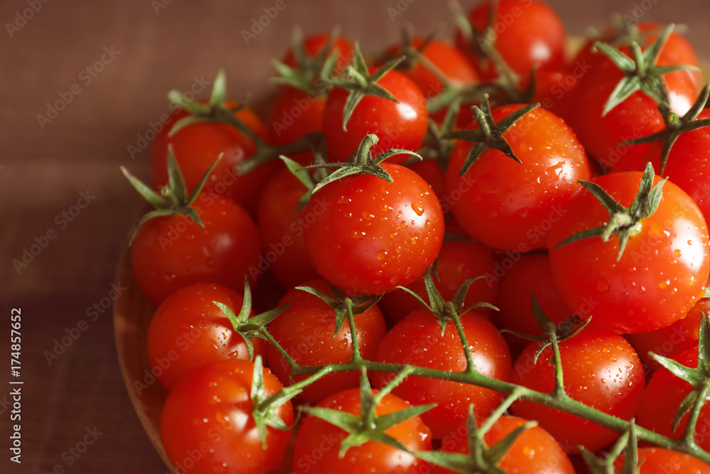 Wooden plate with ripe cherry tomatoes, closeup