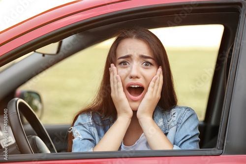 Scared young woman in car