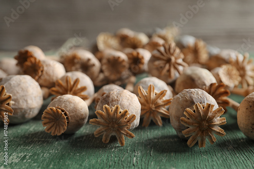 Poppy heads on green wooden table, closeup