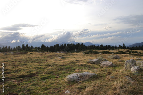 pyrenean meadow and shining sun in cloudy sky in Aude, Occitanie in south of France