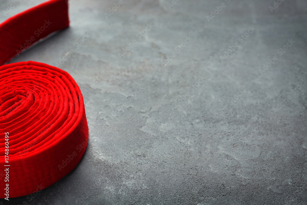 Red karate belt on grey background Red karate belt on grey background