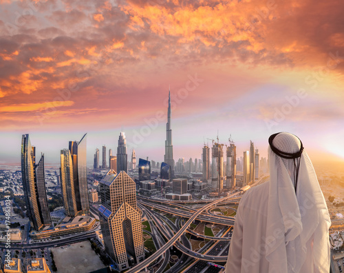 Photo Arabian man watching cityscape of Dubai with modern futuristic architecture in United Arab Emirates