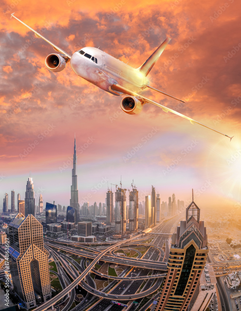 Fototapeta premium Airplane is flying over Dubai against colorful sunset in United Arab Emirates