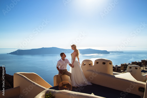 beautiful bride and groom in their summer wedding day on greek island Santorini photo