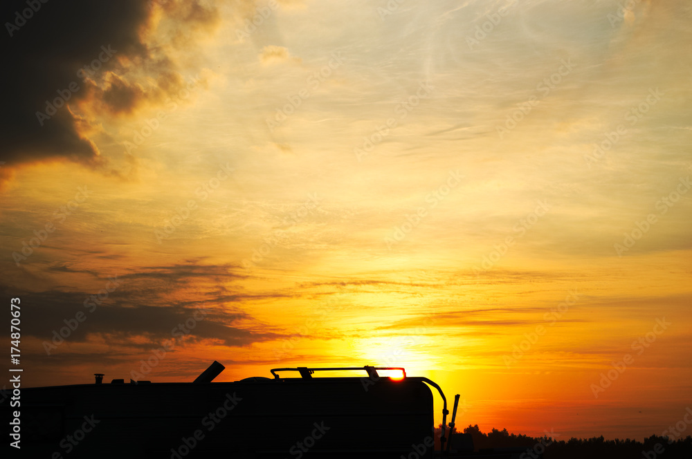 Fototapeta premium Silhouette tramonto con camper e montagne