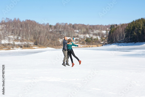 Happy friends jumping on a frozen lake