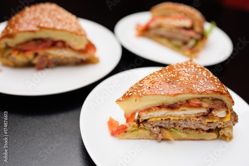 Appetizing slices of a large burger or meat pie closeup.On the table in the restaurant