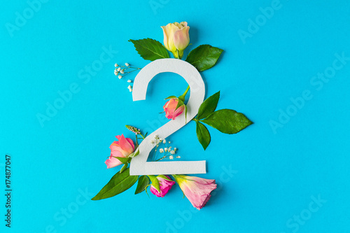 Composition with number 2 and beautiful flowers on color background photo