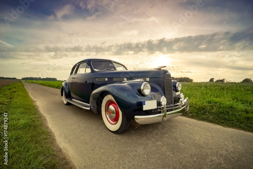Fotobehang Oldtimer Cadillac Lasalle Coupe vor dramatischem Abendhimmel