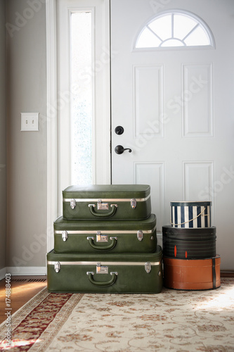 Canvas Print Set of vintage luggage and hatboxes waiting next to a front door.