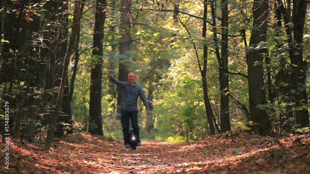 Man riding mono wheel in autumn sunny wood and do selfie photo by smartphone
Man riding mono wheel in autumn sunny wood and do selfie photo by smartphone