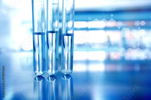 three test tubes with blue in technology science laboratory with chemical structure background