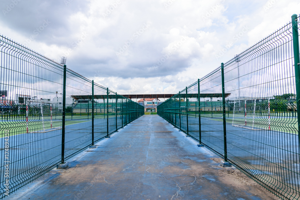 Green Metal fence wire around football field. Green Metal fence wire around football field.