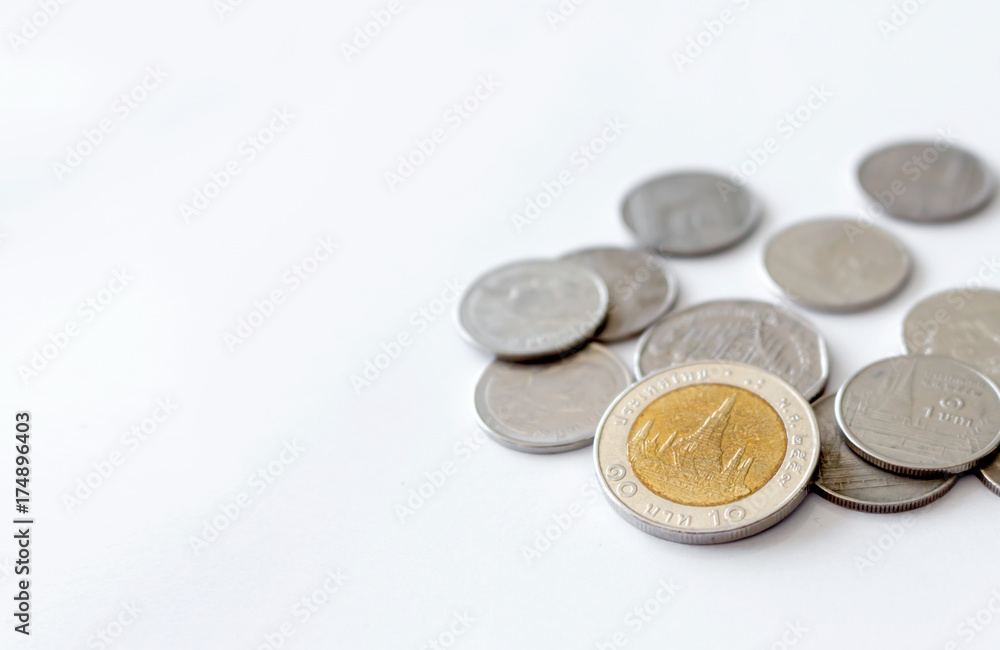 coins (Thai money) on white table with over light and soft-focus in the background coins (Thai money) on white table with over light and soft-focus in the background