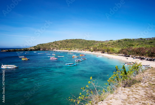 Boats with tourists arriving to beautiful beach on tropical island, Lombok, Indonesia