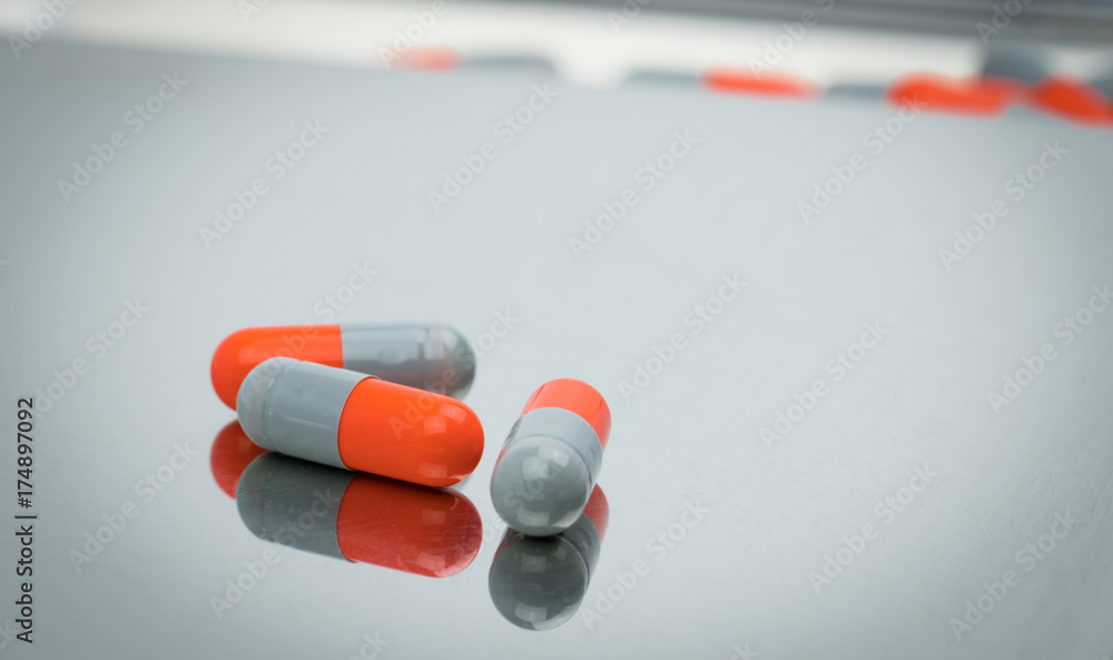Colorful of antibiotic capsules pills with shadows on stainless steel drug tray, drug resistance concept. Colorful of antibiotic capsules pills with shadows on stainless steel drug tray, drug resistance concept.