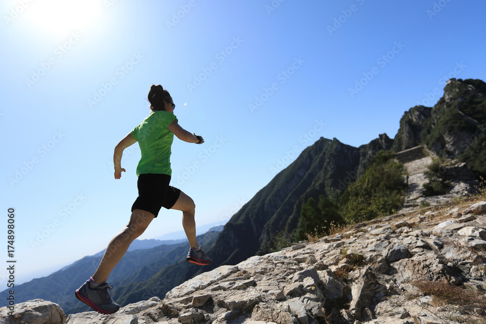 woman trail runner running at mountain top woman trail runner running at mountain top