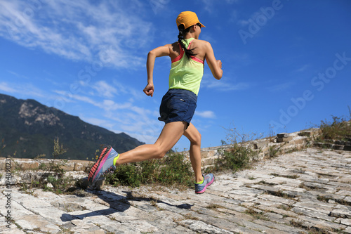 young fitness woman trail runner running on the great wall top of mountain