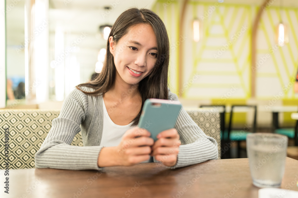 Woman use of smart phone in restaurant Woman use of smart phone in restaurant
