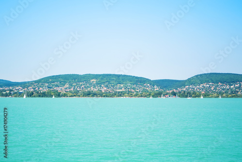 A view from a ship to bright Balaton lake water and coast at the background on sunny summer day, Hungary.
