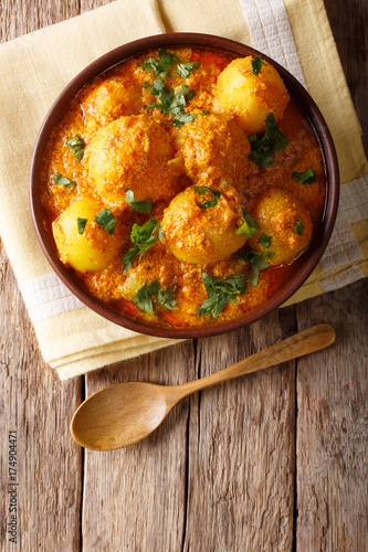 Indian fried potatoes Dum aloo in curry sauce close-up. vertical top view