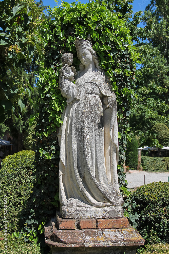 Old statue in the courtyard of Grazzano Visconti castle, Italy