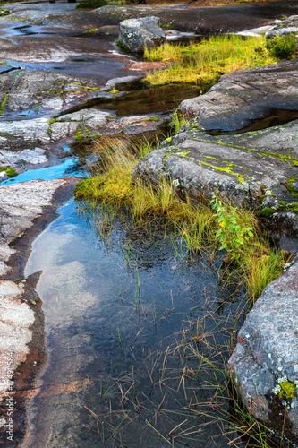 Mirror surface of water  large stones  the sky reflects