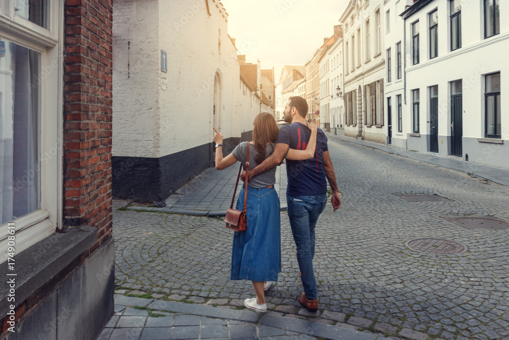 © papa - Young couple of tourists walking the streets of a European city.