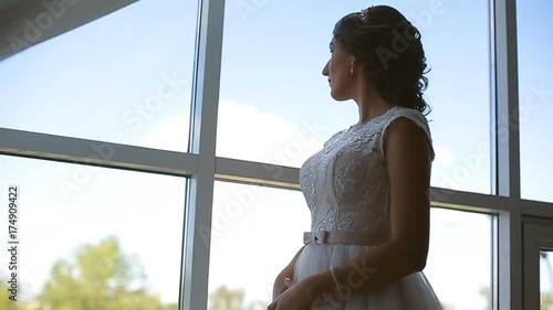 bride in the dress of the big window against the sky