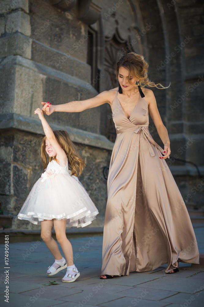 The young beautiful mother playing with her little cute daughter outdoors The young beautiful mother playing with her little cute daughter outdoors