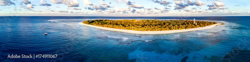 Aerial view of Lady Elliot Island in Queensland Australia with the coral reef in the foreground and clouds in the background.
