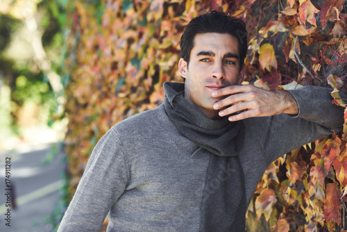 Handsome man wearing winter clothes in wooden background.